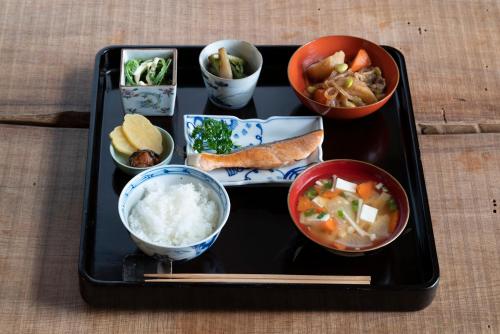 Una bandeja con cuencos de comida sobre una mesa en Noka Minshuku Sanzen, en Tokamachi