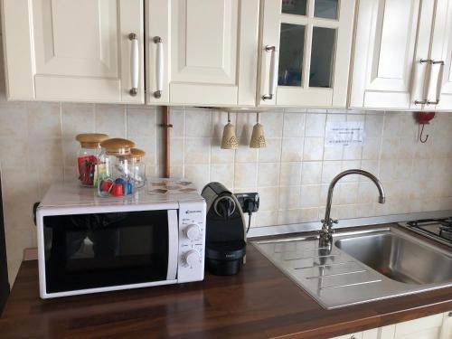 a kitchen counter with a microwave and a sink at AcquaTerraFuoco - City apartments in Como