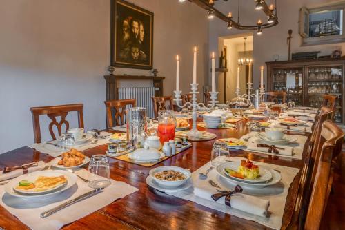 a long wooden table with plates of food on it at Residenza D'Epoca In Piazza della Signoria in Florence
