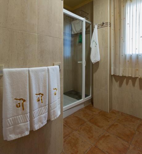 a bathroom with white towels and a shower at Casa O Muiño in Poio