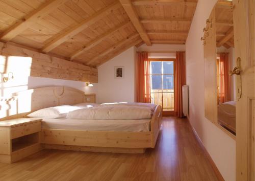 een slaapkamer met een bed in een kamer met houten plafonds bij Appartment Kircherhof in Laion