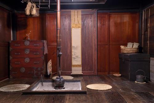 Pokój z drewnianymi ścianami i podłogą z wazonem na podłodze w obiekcie Noka Minshuku Sanzen w mieście Tokamachi