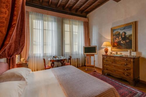 1 dormitorio con 1 cama, vestidor y TV en Residenza D'Epoca In Piazza della Signoria, en Florencia