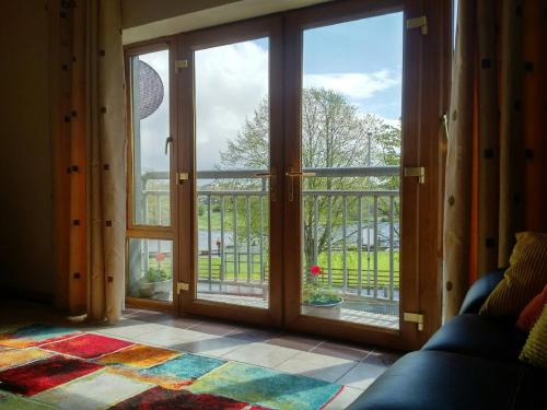 a room with sliding glass doors with a view of a yard at Erne View Apartments 1C - Lakeside Apartment Enniskillen in Enniskillen