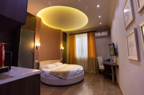 a bedroom with a bed and a large yellow light at Kantar Hotel in Yerevan