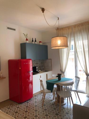 a kitchen with a red refrigerator and a table at Dimora Labbate in Polignano a Mare