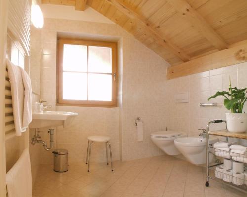 a bathroom with a toilet and a sink and a window at Appartment Kircherhof in Laion