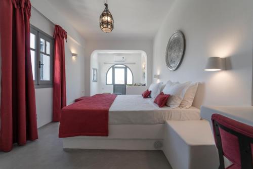 a bedroom with a large bed and a red curtain at Black Coast Santorini in Perivolos