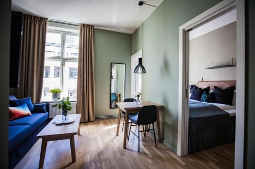 ein Wohnzimmer mit einem blauen Sofa und einem Tisch in der Unterkunft Frogner House - Nationaltheatret in Oslo