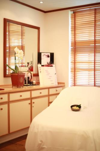a bedroom with a white bed and a mirror at Hotel Stadt Hamburg in Westerland (Sylt)