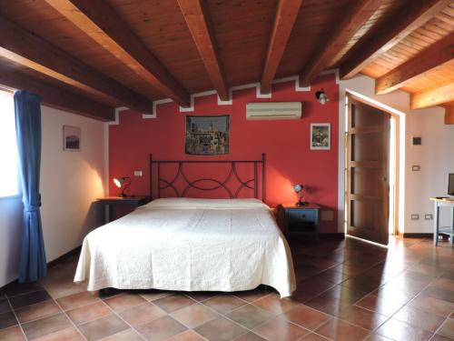 una camera con un letto bianco su una parete rossa di Aziyz Camere a Castellammare del Golfo