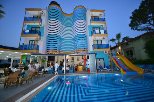 un hotel con piscina frente a un edificio en Yade Luxe Hotel, en Marmaris