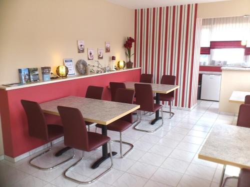 une salle à manger avec des tables, des chaises et un comptoir dans l'établissement Eifel - Pension, à Kall