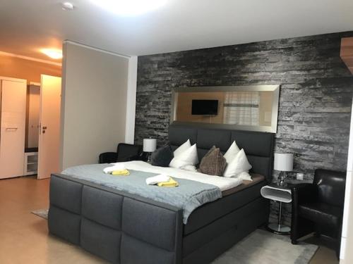 a bedroom with a large bed with a brick wall at Aparthotel Magnolia in Oberursel