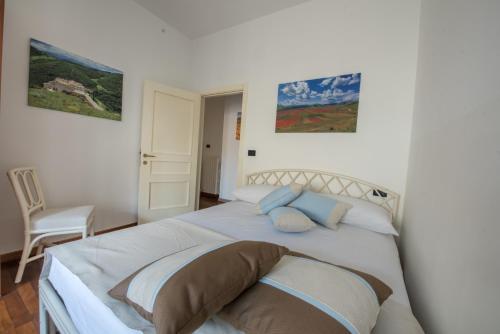 1 dormitorio con 1 cama blanca grande con almohadas en Appartamento in completo confort, en Montegranaro