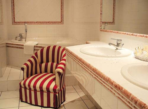 uma casa de banho com uma cadeira, um lavatório e uma banheira em Villa MARSAN - Maison Hervé-Martin GARRAPIT em Villeneuve-de-Marsan