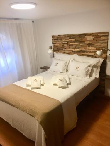 a bedroom with a large white bed with white pillows at Centro Histórico Mezquita Judería La Preferida in Córdoba