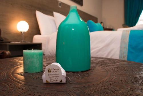 a green vase sitting on a table with a candle at Samana Hotel in Arequipa