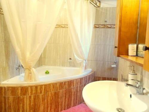 La salle de bains est pourvue d'une baignoire et d'un lavabo. dans l'établissement Cozy apartment in Paradisi, à Paradeísion