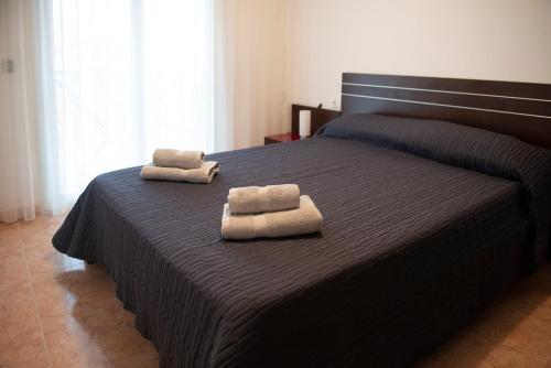 a bedroom with a bed with two towels on it at Apartamento in Santa Susanna