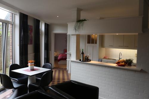 een woonkamer met een tafel en stoelen en een keuken bij Loft at Bruges in Varsenare