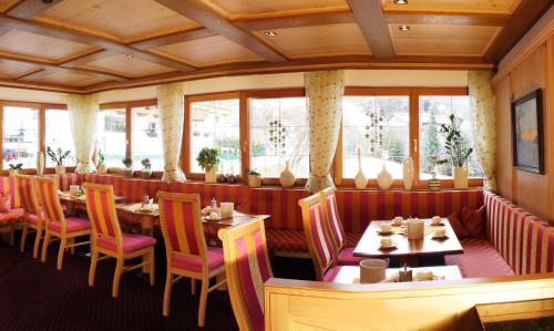 a dining room with tables and chairs and windows at Sportalm in Sölden