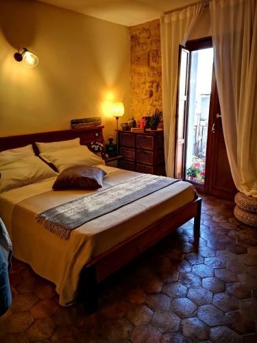 a bedroom with a large bed and a window at Aljama - Downtown B&B in Agrigento