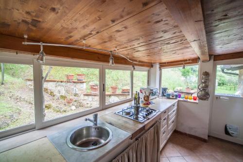 a kitchen with a sink and some windows at Podere Sionne in Chiusi