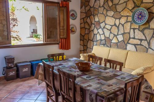 a dining room with a table and a stone wall at Baglio Cracchiolo da Tuzzo - Casa Carrubbo in San Vito lo Capo