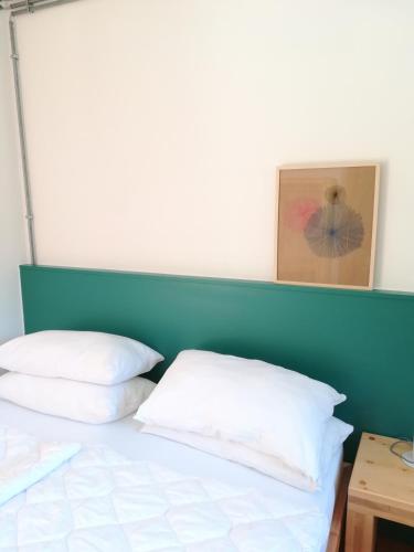 a bed with a blue headboard and white pillows at Limarò B&B in Sarche di Calavino