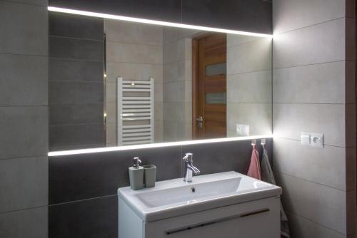 ein Badezimmer mit Waschbecken und Spiegel in der Unterkunft Pokoje Gościnne 4 Pory Roku in Klimkówka