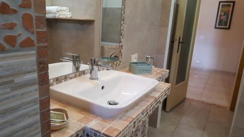 uma casa de banho com um lavatório branco e um espelho. em Casa vicino al mare em Piombino