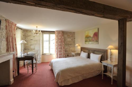 een hotelkamer met een bed en een bureau bij Le Marius in Les Riceys