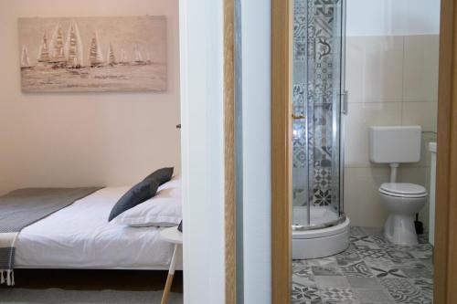 a bedroom with a bed and a shower and a toilet at Studio Terrace Borgoforte in Trogir