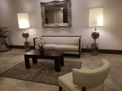 a living room with a couch and a table and a mirror at LUXURY APARTMENT PUERTO SANTA ANA GUAYAQUIL in Guayaquil