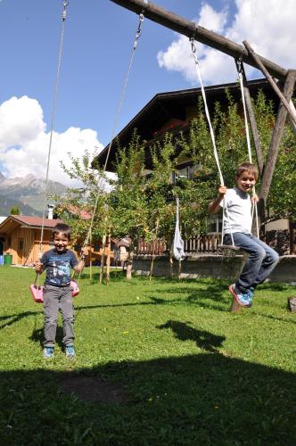 two young boys are playing on a swing at Haus Freispitzblick in Bach