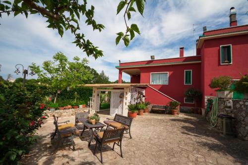 a red house with chairs and a table in front of it at Villa Giacomina in Fasano