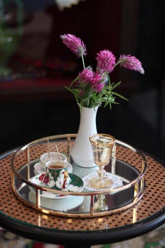 a table with a tray with a vase with flowers at Armida City Hotel in Çanakkale