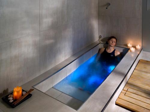 a woman in a swimming pool in a room at Hotel Universal Terme in Abano Terme