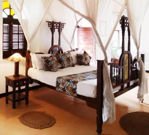 una camera da letto con un letto a baldacchino di The Swahili House a Zanzibar City