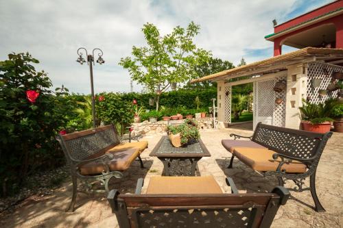 a patio with two chairs and a table and a bench at Villa Giacomina in Fasano