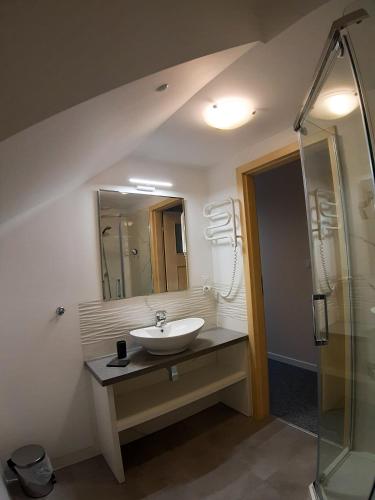 a bathroom with a sink and a shower at Pokoje gościnne Anna in Rewa