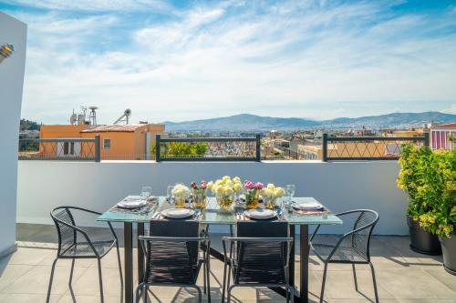 a table on a balcony with a view of the city at Mythos Luxury Suites in Athens