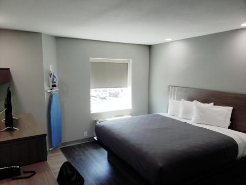 Un dormitorio con una cama grande y una ventana en Hathaway Inn, en Panama City