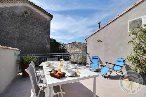 - une table blanche avec un bol de nourriture sur la terrasse dans l'établissement Gîte de l'Eclotine, à Saint-Théodorit
