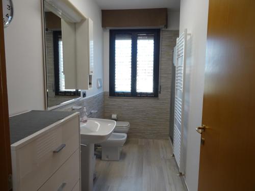 bagno con lavandino, servizi igienici e finestra di W LE VACANZE a Rimini