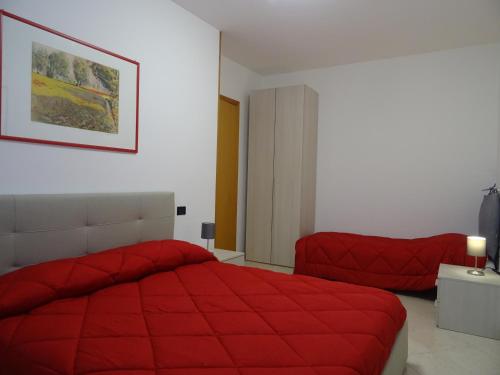una camera con letto rosso e sedia di W LE VACANZE a Rimini