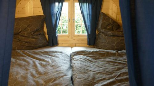 2 Betten in einem Zimmer mit Fenster in der Unterkunft Gemütliches Schlaffass am Schwimmteich mit Heizung in Burg