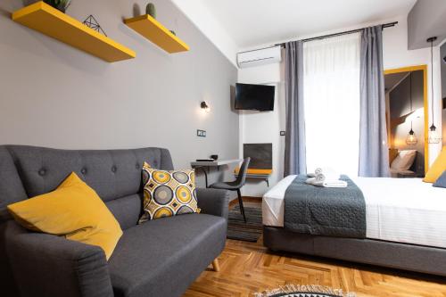 sala de estar con sofá y cama en Downtown Luxury Boutique Suites : the yellow suite, en Tesalónica