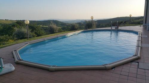 a large swimming pool on a patio with a view at Agriturismo La Meria in Semproniano